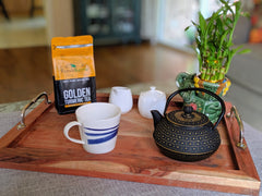 Golden turmeric healthy tea package shot along with tea set